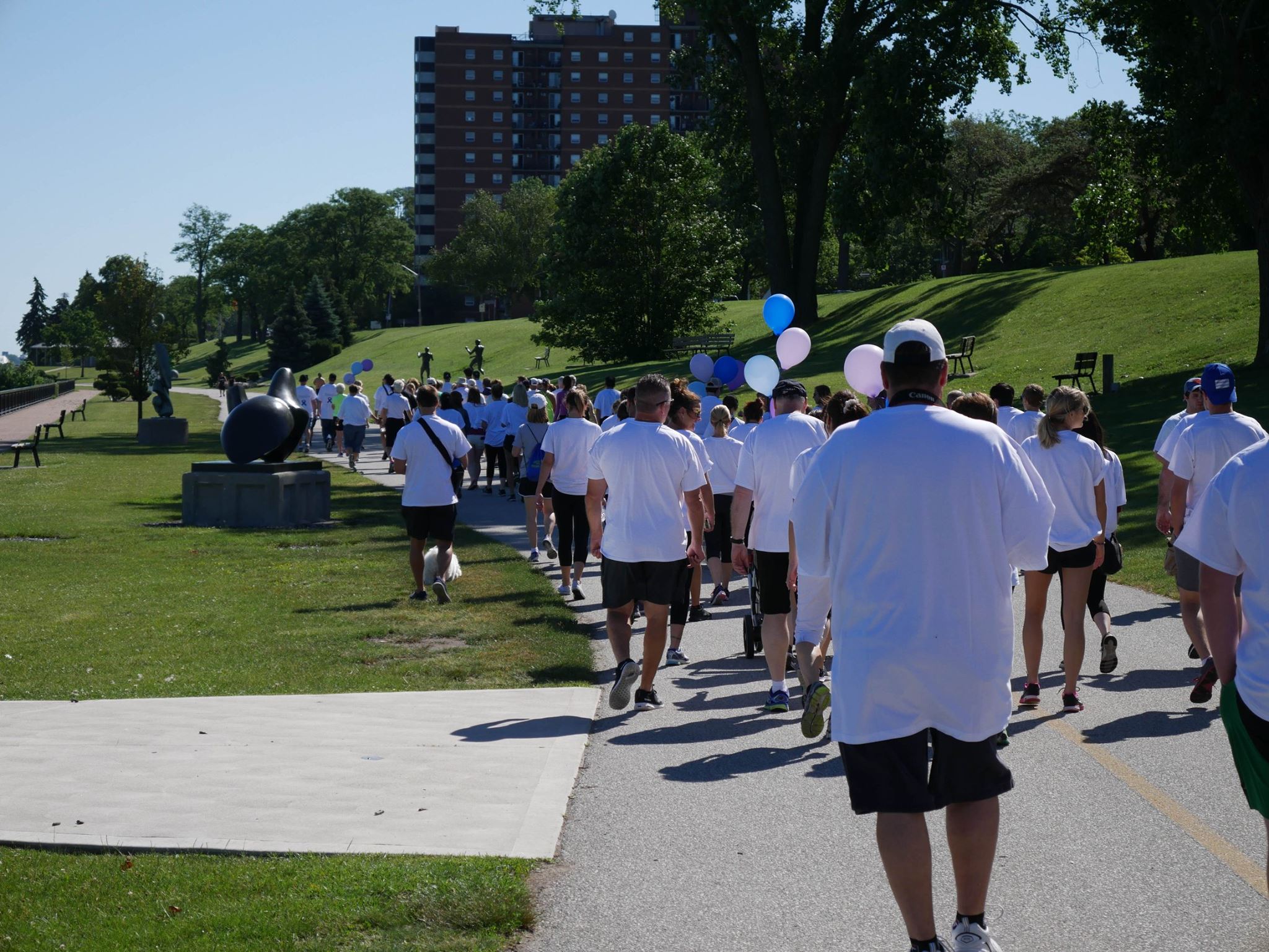 Group of people walking with blue and purple balloons at the Windsor Walk