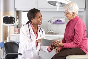 Doctor discussing records with senior female patient SMALL