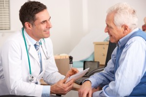 Doctor talking to senior man in surgery SMALL